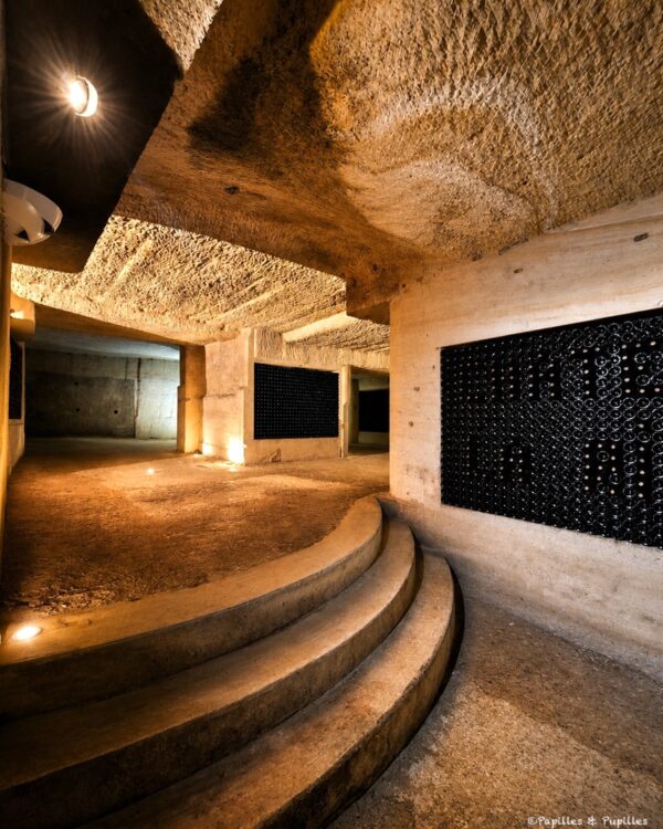 Escalier courbe et casiers à bouteilles dans les caves du Château de La Rivière