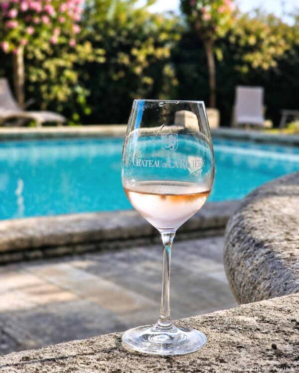 Verre de rosé Château de La Rivière devant la piscine du château